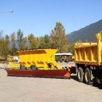 A tow plow being pulled behind a plow truck