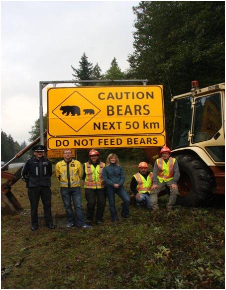 Workers in Front of Bear Warning Sign on Highway 99
