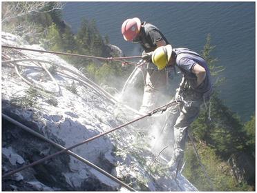 workers clearing debris from rockface