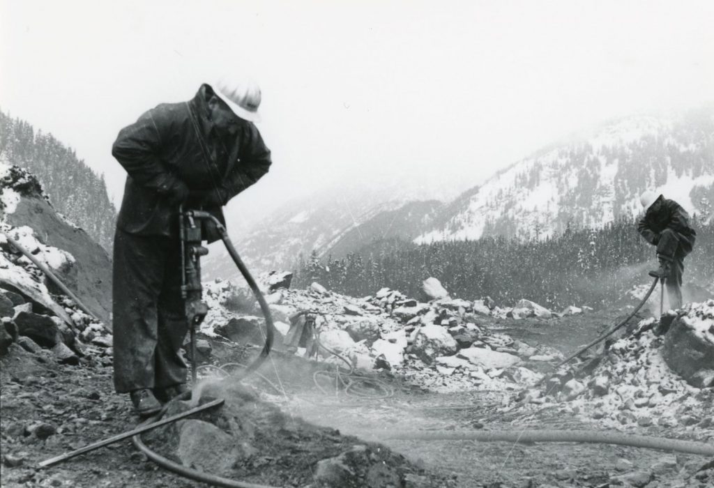 Ministry staff drilling to clear a new route through the slide site on BC Highway 3.