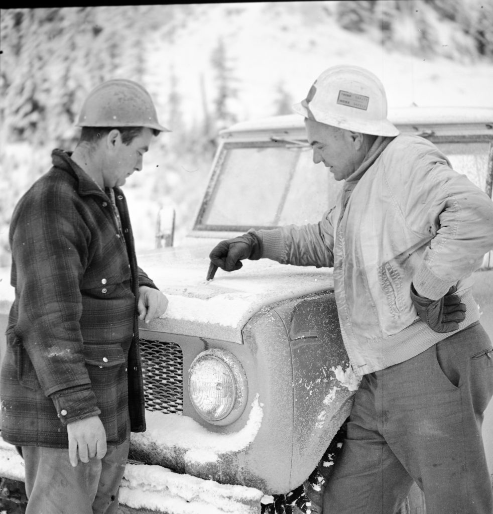 Staff use snow on the hood of a truck to draw plans during recovery.