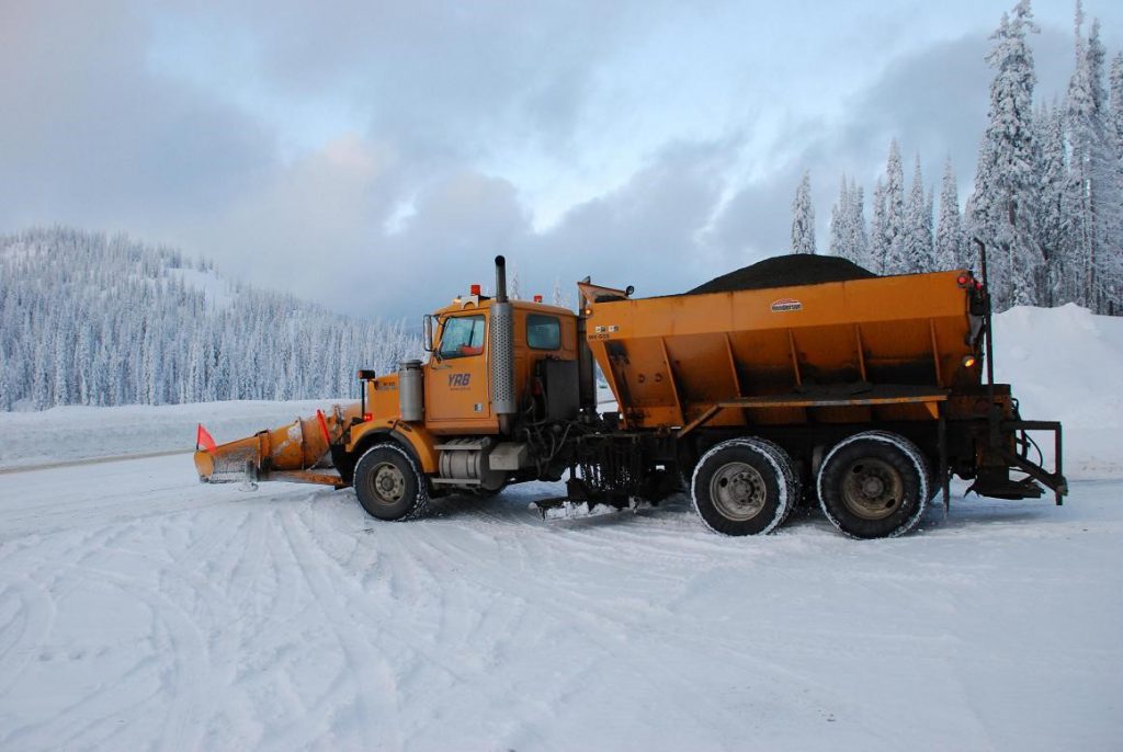 A front plow with an aggregate hopper on the back to dispense sand, gravel or de-icing materials to apply extra traction to the road after plowing.