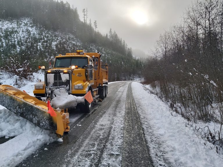 A snow plow clears snow from a BC Highway