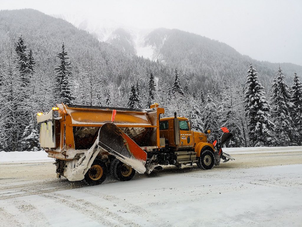 A side view of a plow truck with wing plow, underbody plow, front plow and hopper. Truly a tool for every snow occasion.