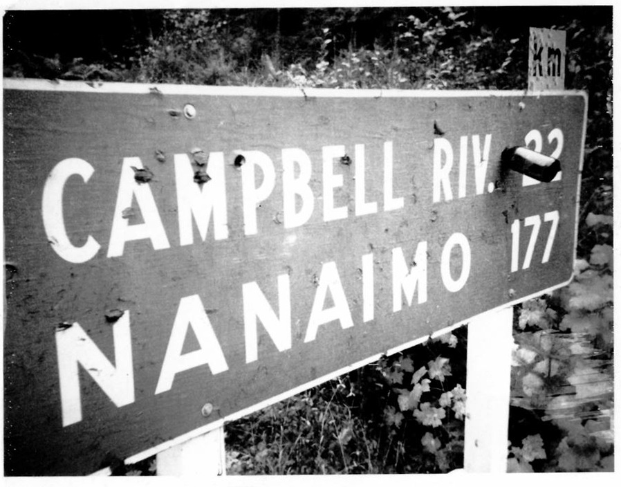 This snapshot of a road distance sign (circa late 1970s) shows ways in which signage can become damaged and why they might need to be replaced.