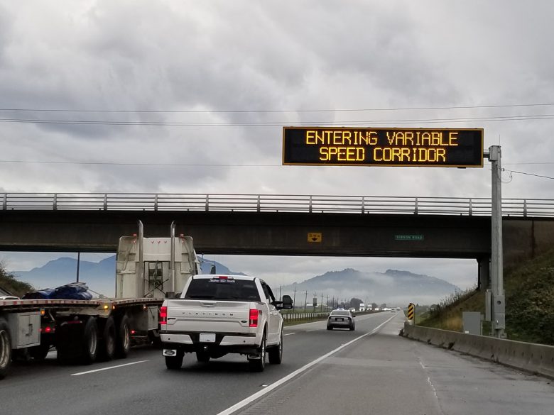 Variable speed sign with trucks driving underneath