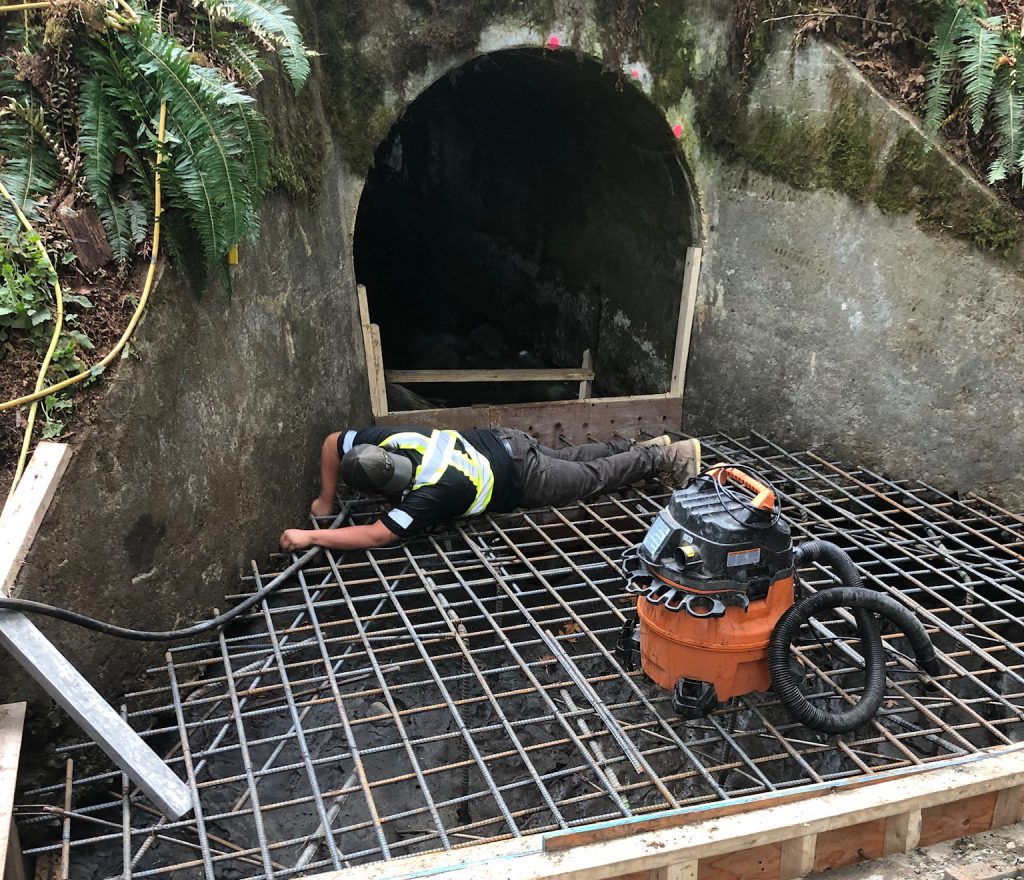 Worker repairing culvert