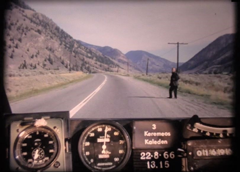 Man in black hitchhiking outside of Keremeos