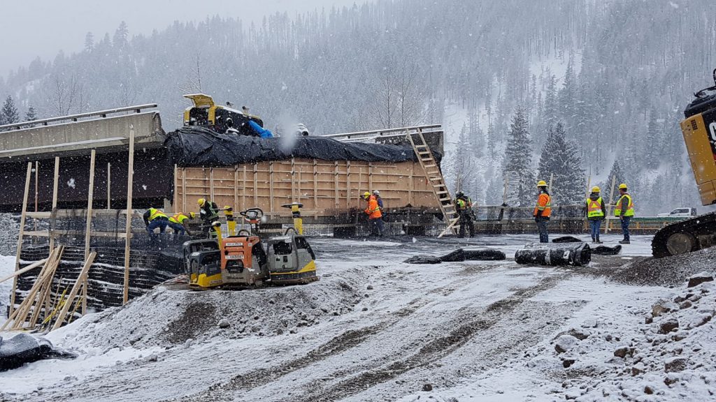 Crews working to re-establish a bridge span connection at Bottletop Bridge on BC Highway 5 (the Coquihalla) during a snowstorm in December 2021. More than 300 workers using 200 pieces of equipment moved more than 400,000 cubic metres of gravel, rock and other material to repair and reopen Highway 5 to commercial vehicle traffic in 35 days.