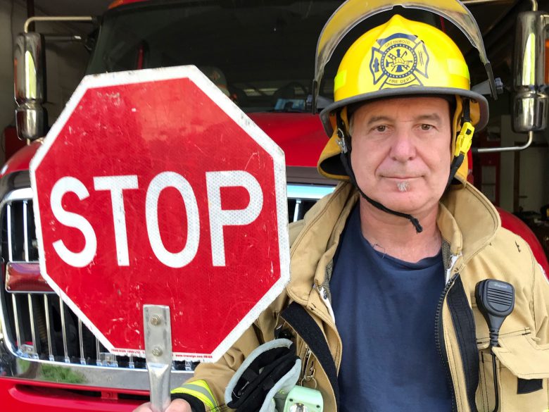 firefighter holding stop sign