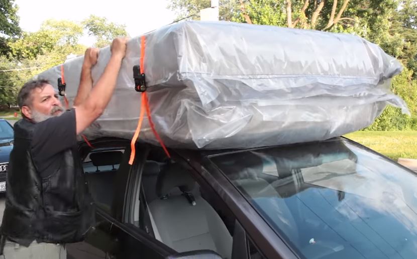 Man secures mattress to vehicle