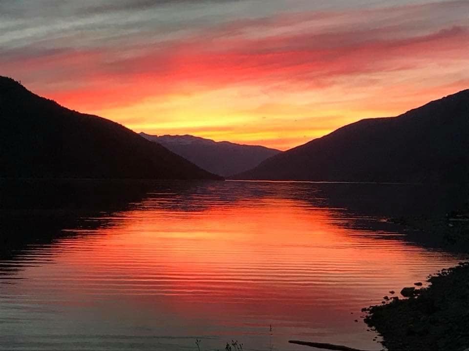sunset of orange, yellow, red reflecting off lake